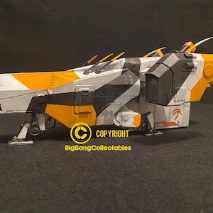May include: A model spaceship with a futuristic design. The spacecraft has a colour scheme of white, black, and orange. The model has a detailed design with various panels, fins, and landing gear. The text "BigBangCollectables" and a copyright symbol are visible.