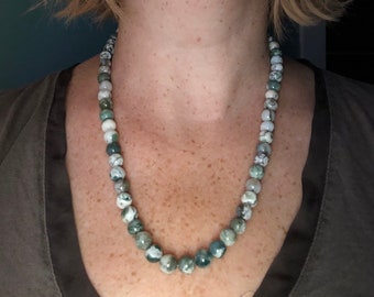 May include: A green and white agate bead necklace. The beads are round and have a natural, polished finish.