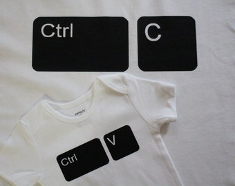 May include: Two white t-shirts with black keyboard key graphics. The larger shirt has "Ctrl" and "C" keys. The smaller shirt has "Ctrl" and "V" keys.