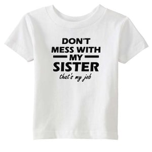 Puede incluir: Camiseta blanca con texto negro que dice "No te metas con mi hermana, ese es mi trabajo".