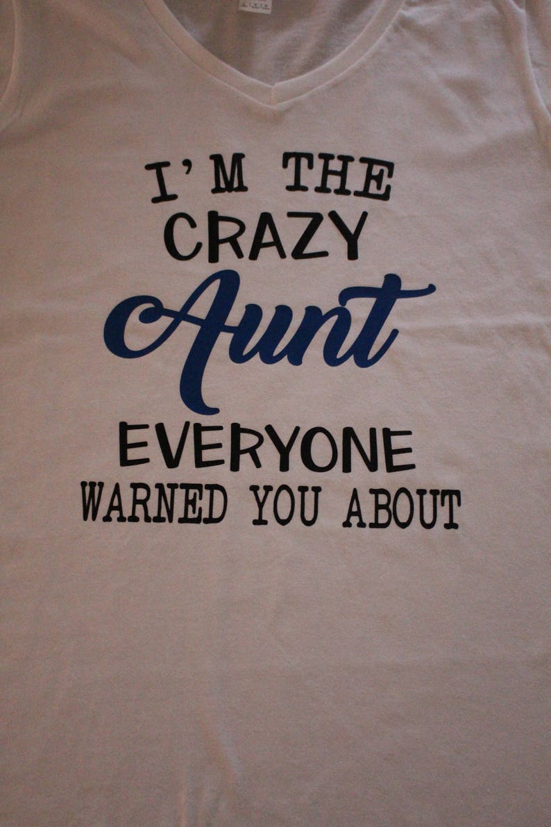 May include: White t-shirt with black text that reads "I'm the crazy Aunt everyone warned you about". The word "Aunt" is in blue cursive.