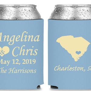 May include: Two light blue can coolers with white text. One cooler says "Angelina & Chris May 12, 2019 The Harrisons". The other cooler has an outline of South Carolina with a heart in the middle and says "Charleston, SC".