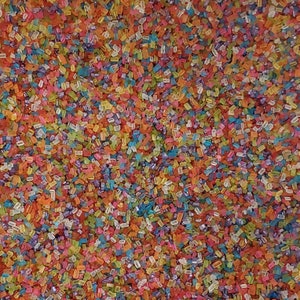 May include: A close-up image of colorful sprinkles, a mix of red, orange, yellow, green, blue, and purple. The sprinkles are small and rectangular in shape.