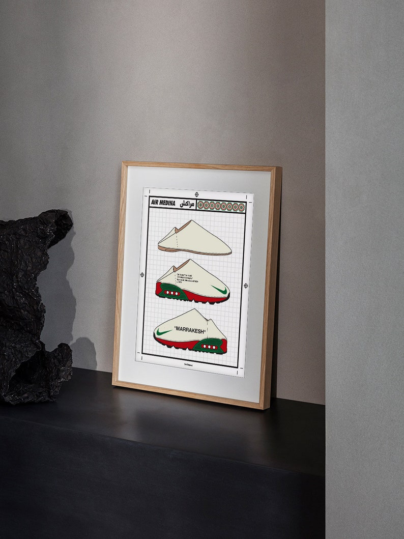 May include: Framed print featuring three stylized illustrations of sneakers. The print includes the text "AIR MEDINA" and "MARRAKESH". The sneakers are depicted in white, red, and green, with a grid background and a wooden frame.