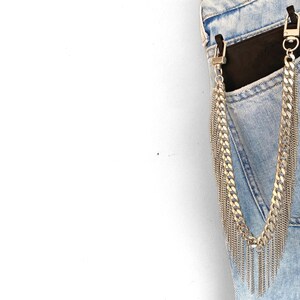 Silver phone strap dropping from a phone case showing its design and movement of fringes