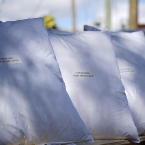 May include: Four white down feather pillows with the text "Florida Foam Down Feather 1800" printed on each pillow.