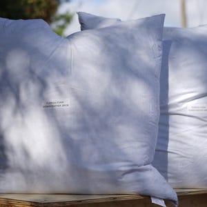 Puede incluir: Dos fundas de almohada blancas con el texto "Zuzanna Kam  Gdańsk, Polonia" impreso en ellas.