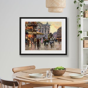 May include: A framed painting depicting a Parisian street scene with people walking and a horse-drawn carriage. The painting is set against a backdrop of buildings with a golden sunset in the background.