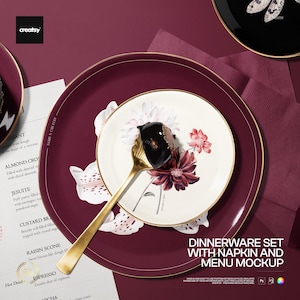 May include: A dinnerware set featuring a large deep red plate with a gold rim, a smaller white plate with a floral pattern and gold rim, and a gold spoon holding a dark chocolate dessert. A menu and a folded deep red napkin are visible.