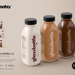 May include: Three glass bottles with black lids and labels that say "glassbottle" in white text. The bottles are filled with different colored liquids: white, brown, and light brown.