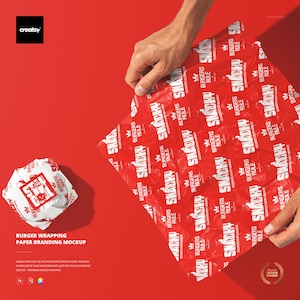 Może przedstawiać: Czerwony makieta papieru do pakowania burgerów z białym napisem "SNACKY BURGERS RULE". Papier jest trzymany w dłoniach, a zawinięty burger znajduje się po lewej stronie. Tło jest jednolicie czerwone.