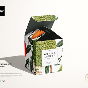 May include: A white box with a black lid, open to reveal a 30cl scented candle. The box is decorated with a watercolour illustration of tropical fruit and leaves. The text "SCENTED CANDLE MOCKUP SET" is printed on the front of the box.