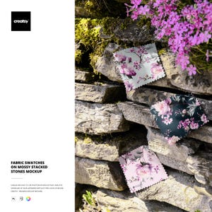 Puede incluir: Muestras de tela con estampados florales en rosa, blanco y verde oscuro se muestran en una pared de piedra cubierta de musgo. Las muestras presentan una variedad de flores rosas. La imagen incluye el texto "FABRIC SWATCHES ON MOSSY STACKED STONES MOCKUP".