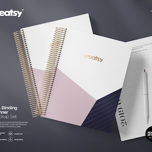 May include: A mockup set of two coil-bound planners with a geometric design in pink, blue, and white. The planner on the left has a gold spiral binding and the planner on the right has a white pen on top of it. The text "creatsy" is printed in gold on both planners. The text "2019" is printed in gold on the right planner.