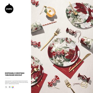 Könnte beinhalten: Ein festliches Weihnachts-Tischgeschirr-Mockup mit Tellern, Tassen und Besteck. Die Teller und Tassen sind mit einem Poinsettia- und Stechpalmen-Design verziert. Goldfarbene Gabeln und Messer sind mit roten Servietten und Süßigkeiten-Ornamenten angeordnet. Das Wort "Esthetic" ist auf die Teller gedruckt.