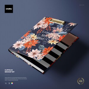 May include: A navy blue clipfolio mockup set with a floral design. The cover features orange, pink, and yellow flowers with the text "LIVING MY BEST LIFE". The interior has black and white stripes and a gold clip.