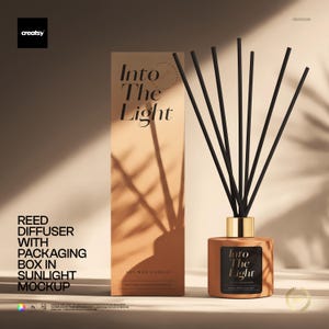 May include: A reed diffuser with a tan bottle, a gold collar, and black reeds, accompanied by a tall tan rectangular packaging box. Both the bottle and the box feature the text "Into The Light" in a black serif font, set against a neutral background.