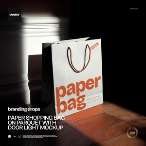 May include: A white paper shopping bag with the words "paper bag" in orange. The bag has brown rope handles and is on a wooden floor. The text "PAPER SHOPPING BAG ON PARQUET WITH DOOR LIGHT MOCKUP" is also visible.