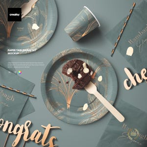 Könnte beinhalten: Ein Mockup-Set für Papiergeschirr mit Tellern, Bechern, Servietten und einem Strohhalm. Die Teller und der Becher haben einen tealfarbenen Hintergrund mit einem goldenen Palmenmuster. Ein Stück Schokoladenkuchen liegt auf einem Teller.