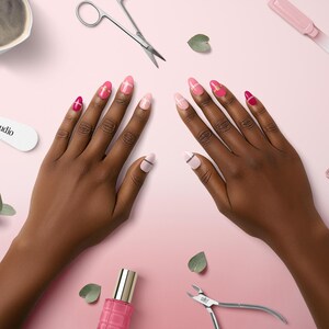 May include: Overhead view of hands with pink and red manicured nails, surrounded by nail polish, clippers, scissors, and a file on a pink surface. A cup of coffee and a nail file with "Nail Studio" text are also visible. The scene suggests a nail care theme.