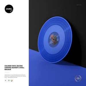 Peut inclure: Un disque vinyle bleu appuyé contre un mur noir. Le disque a une étiquette bleue au centre. L'image est une maquette avec le texte "Colored Vinyl Record Leaning Against a Wall Mockup".