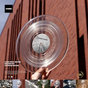 Peut inclure: Maquette de disque vinyle transparent avec le mot "TOGETHER" sur l'étiquette. Le disque est tenu devant un mur de briques rouges. Le texte "CLEAR VINYL RECORD MOCKUP SET OUTDOOR EDITION" est également visible.