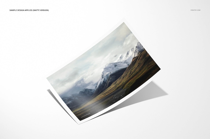 May include: A photograph of a mountain range with snow-capped peaks and a valley covered in green grass. The sky is cloudy and the mountains are in the distance.