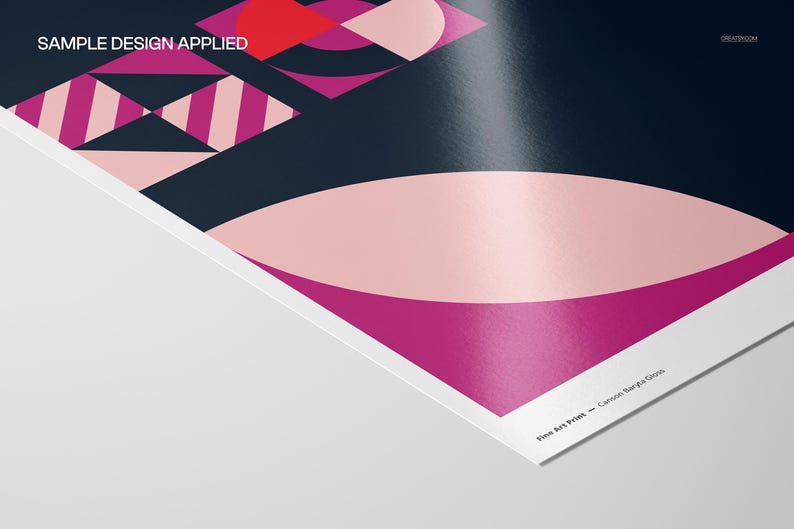 Op de afbeelding: Een close-up van een fine art print met een geometrisch ontwerp. De print toont vormen in roze, rood en marineblauw. De tekst "SAMPLE DESIGN APPLIED" is zichtbaar bovenaan. De print heeft een glanzende afwerking.