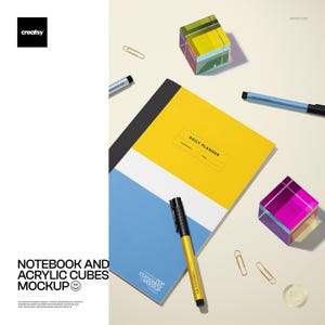 May include: A notebook with a yellow and blue cover, a gold pen, and two iridescent acrylic cubes. The notebook has the words "DAILY PLANNER" on the cover. Also included are paperclips and pens. The image is a mockup.