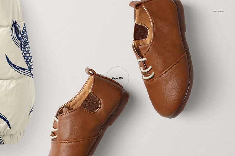 Op de afbeelding: Twee bruine leren veterschoenen met witte veters. De schoenen liggen op een wit oppervlak.