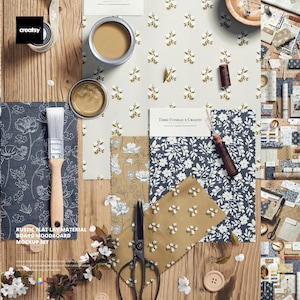 Op de afbeelding: Een platte lay-out met stofstalen met bloempatronen, verfblikken, een penseel en een schaar. Het kleurenpalet omvat tinten bruin, beige en marineblauw. De tekst op de afbeelding luidt "RUSTIC FLAT LAY MATERIAL BOARD MOODBOARD MOCKUP SET".