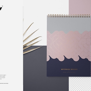 May include: A spiral bound notebook mockup with a pink and gold geometric design on the cover. The notebook is on a gray background with a gold leaf in the corner.