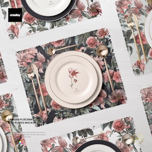 Könnte beinhalten: Eine Tischdekoration mit weißen Tellern, goldenem Besteck und floralen Tischsets. Die Tischsets haben einen dunklen Hintergrund mit rosa und roten Blumen. Das Bild enthält den Text "FRINGED PLACEMAT AND PLATES MOCKUP".