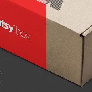 May include: A red and brown cardboard box with the text "creatsy box" printed on the red side. The box is partially open, revealing the inside.
