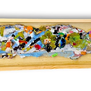 Puede incluir: Un marco de madera largo y estrecho encierra una obra de arte abstracta colorida hecha de pintura y papel texturizados en capas. La obra es una mezcla vibrante de azules, verdes, amarillos, naranjas y rojos, creando una composición dinámica y enérgica.