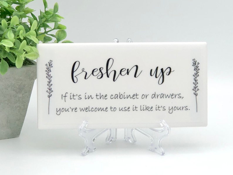 May include: White ceramic tile with black text that reads "freshen up" and "If it's in the cabinet or drawers, you're welcome to use it like it's yours."