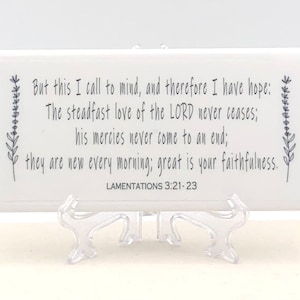 May include: White rectangular plaque with a black floral design and the text "But this I call to mind, and therefore I have hope: The steadfast love of the LORD never ceases; his mercies never come to an end; they are new every morning; great is your faithfulness. LAMENTATIONS 3:21-23"