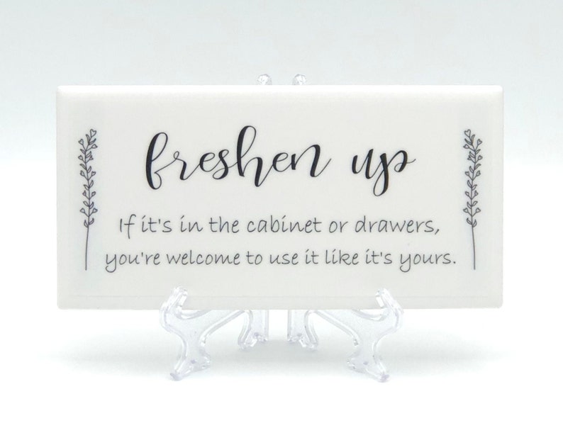 May include: White ceramic tile with black text that reads "freshen up" and "If it's in the cabinet or drawers, you're welcome to use it like it's yours."