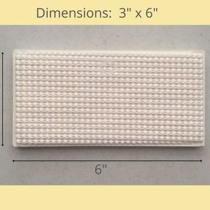 May include: A white, rectangular non-slip mat with a textured surface. The mat measures 3 inches by 6 inches.