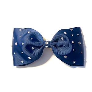 May include: A navy blue bow with silver rhinestones. The bow is made of grosgrain ribbon and has a center loop.