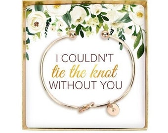 May include: A gold bangle bracelet with a knot charm and a small round tag that says "I couldn't tie the knot without you". The bracelet is in a white box with a floral design and the words "One Day Sale".