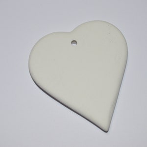 Può includere: Ciondolo a forma di cuore in ceramica bianca con un foro per appenderlo.