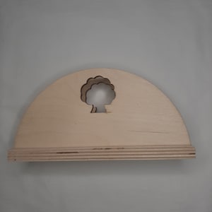 May include: A light-colored wooden shelf with a semi-circular top and a rectangular base. A tree-shaped cutout is centered on the top. The shelf is made of layered wood, and the design is simple and natural.
