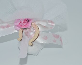 Könnte beinhalten: Eine weiße Tülltasche mit einem rosa Satinband und einer rosa Blume. Die Tasche ist mit einem Holz-Hufeisen-Anhänger gebunden.