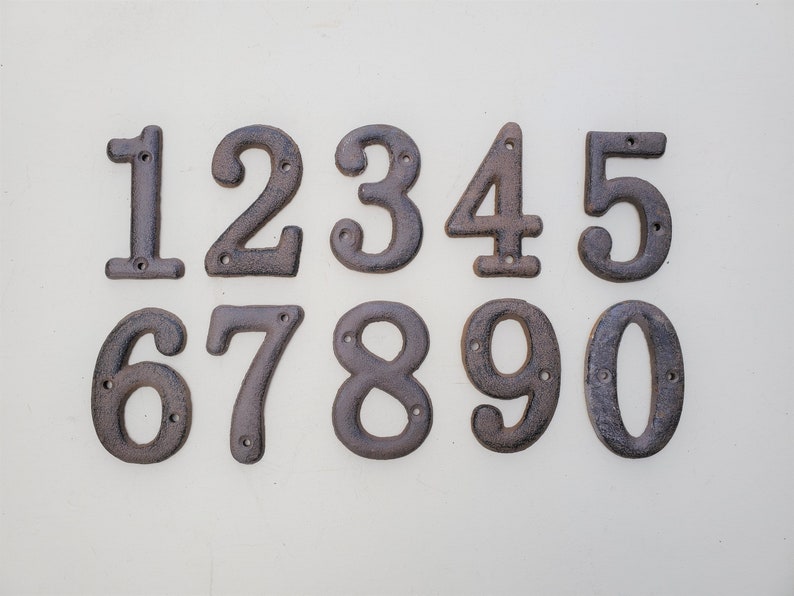 May include: Ten black metal house numbers, 1 through 10, with a rustic finish. Each number has two holes for mounting.