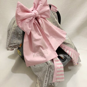 光沢のあるシルバーのスパンコールとピンクのリボンが付いた女の子用カーシートキャノピーカバー、パーソナライズされたカーシートキャノピーカバー