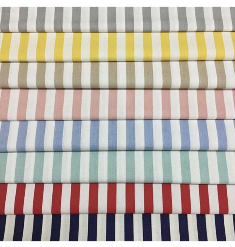K&ouml;nnte beinhalten: Eine Sammlung von gestreiften Stoffmustern in verschiedenen Farben, darunter Grau, Gelb, Beige, Rosa, Blau, Gr&uuml;n, Rot und Marine.