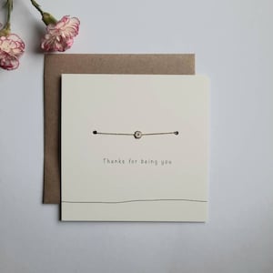 Armbandje met bloem wit op kaart. Thanks for being you.