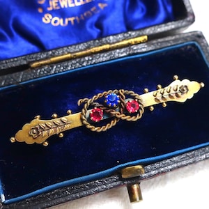 Antik viktoriansk brosch i 9 karat gult guld med blå och röda klistrar, med brosch i Chester-märken från 1897, i antik ask.