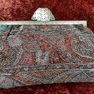 Circa 1900 paisley shawl fabric clutch with intricate steel bead work.